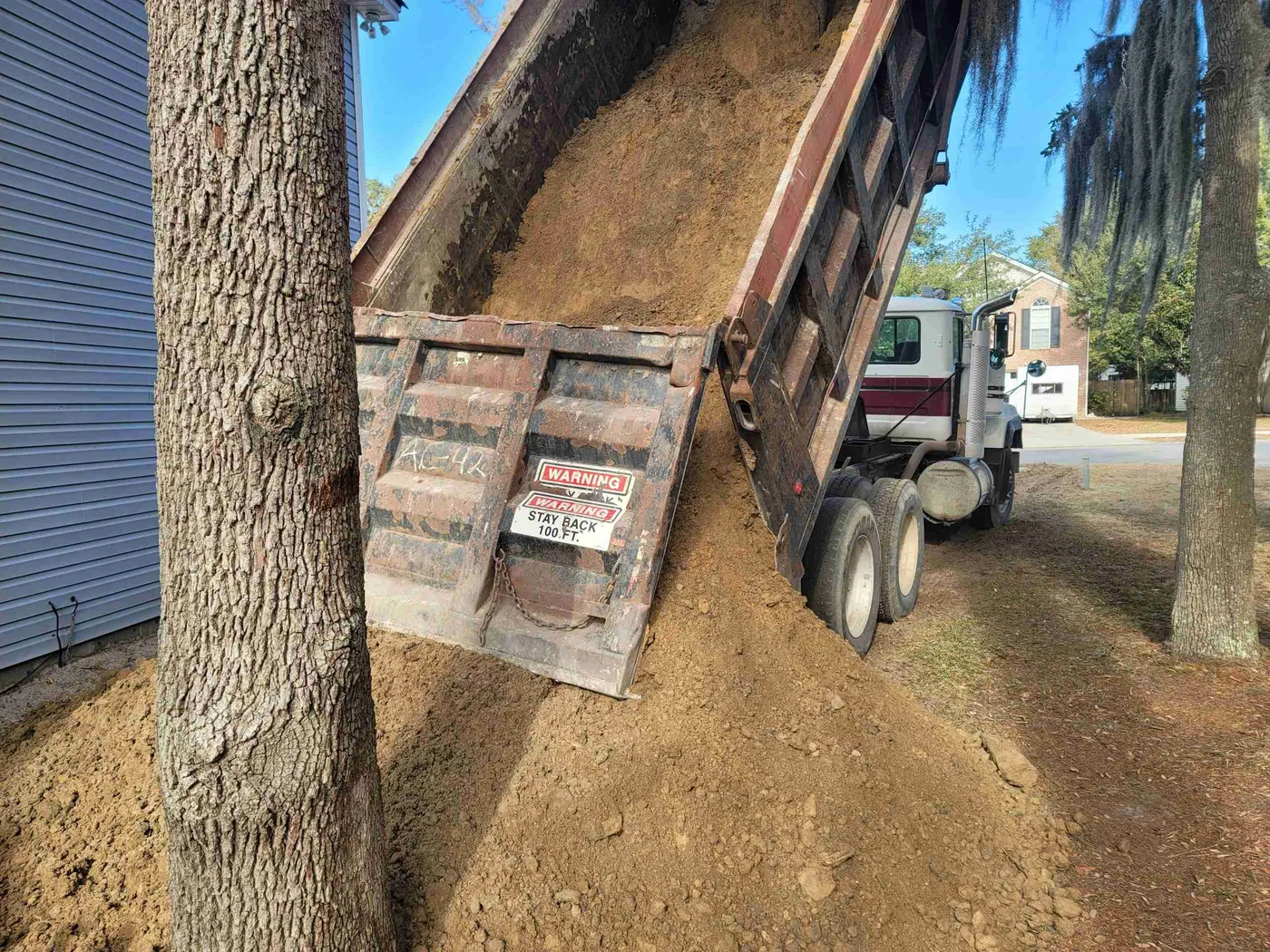 Tandem dump truck bed loaded with sand ready for delivery