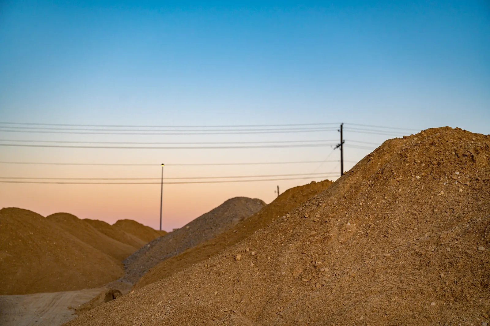 Piles of sand and fill dirt at dusk